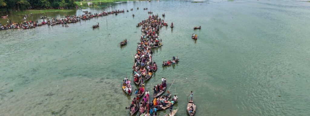 Aerial view of a traditional river boat race with spectators along the bank